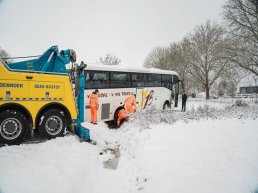Touringcar vast in greppel op Strandboulevard